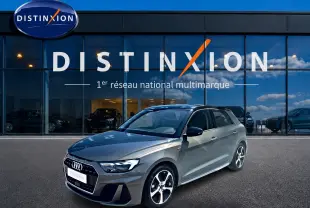 Audi A1 Sportback gris chronos vue 3/4 avant droit, avec jantes alu et toit noir devant vitrine Distinxion.
