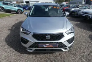 Vue frontale d'un SEAT Ateca gris clair 2023 avec calandre noire et plaques du concessionnaire visible.