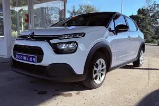 Citroën C3 blanc vue 3/4 avant droit, avec toit noir et protections noires autour des roues.