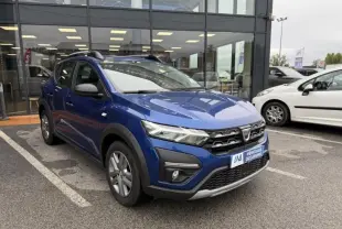 Vue 3/4 avant d'une Dacia Sandero Stepway bleu métal 2022 avec calandre noire et protections plastiques noires.