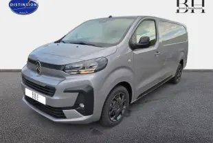 Vue 3/4 avant droit d'un Citroën Jumpy Fourgon XL gris acier métal avec phares allumés et jantes noires.