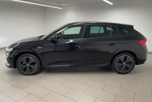 Vue de profil côté gauche d'une Skoda Scala 2025 noire métallisée avec jantes spécifiques Monte-Carlo et double plancher de coffre.