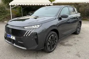 Peugeot 3008 Hybrid 145 GT gris titane en 3/4 avant droit, avec jantes alliage bicolores et calandre noire distinctive.