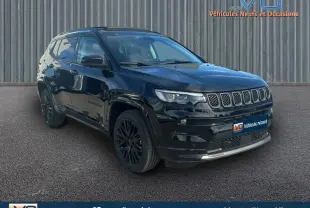 Jeep Compass noir en 3/4 avant gauche, avec jantes alliage noires et barres de toit visibles sur fond urbain.