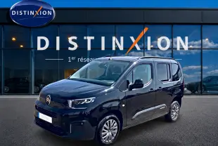Citroën Berlingo noir vue 3/4 avant droit, avec barres de toit et jantes alu devant showroom Distinxion.