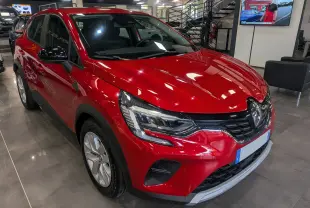 Renault Captur TCe 90 CH ZEN rouge Flamme en 3/4 avant droit, avec phares LED et jantes alliage visibles en showroom.