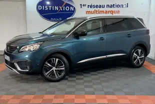 Vue latérale droite d'un Peugeot 5008 bleu métallisé, avec jantes alliage et toit chromé dans un showroom.