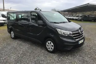 Renault Trafic Combi gris comète vu en 3/4 avant droit, véhicule utilitaire avec grandes vitres latérales.