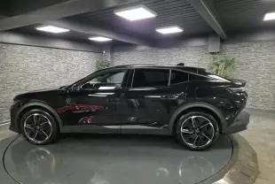 Peugeot 408 noire vue de profil droit en intérieur, avec jantes alliage 19 pouces et toit noir Mistral.