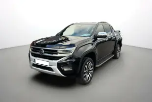 Volkswagen Amarok V6 noir en 3/4 avant droit avec jantes alu 21 pouces et barres de toit visibles.