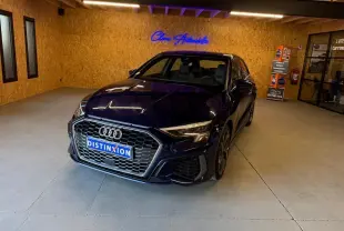 Audi A3 2.0 TDI S-Line bleu vue 3/4 avant droit dans un showroom avec mur en bois et enseigne lumineuse.