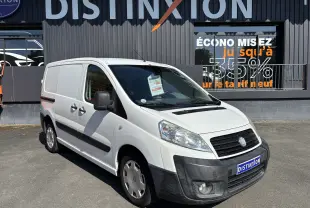 Fourgon FIAT Scudo blanc en 3/4 avant droit, avec pare-chocs noir et logo Distinxion visible sur la plaque avant.