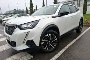 Peugeot 2008 blanc nacré vue 3/4 avant droit, avec jantes noires et détails noirs contrastants sur carrosserie.