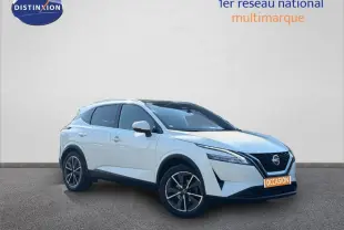 Nissan Qashqai blanc en 3/4 avant droit, avec jantes alliage noires et calandre distinctive V-Motion.