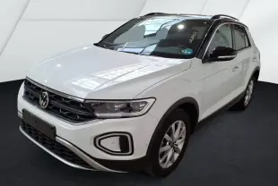 Volkswagen T-Roc blanc en 3/4 avant droit, avec toit noir et jantes alliage, sur fond neutre intérieur.