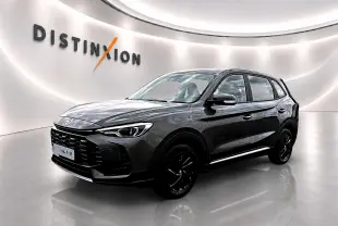 MG Motor ZS 1.5 hybrid 197 Camden grey en 3/4 avant droit, avec calandre noire et jantes sombres dans un showroom lumineux.