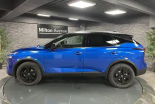 Vue de profil côté gauche d'un Nissan Qashqai 1.3 Mild Hybrid 140 Shadow bleu avec toit noir et jantes noires.