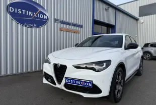 Vue 3/4 avant droite de l'Alfa Romeo Stelvio blanc Alfa 2023 avec calandre caractéristique et phares LED distinctifs.