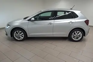 Profil droit d'une Volkswagen Polo 1.0 TSI 95 BVM5 Style 2025 en peinture reflet d'argent, avec feux avant allumés.