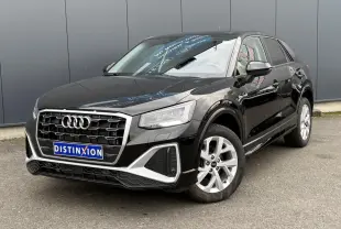 Audi Q2 noir métallisé en vue 3/4 avant droit, mettant en valeur sa calandre distinctive et ses jantes S line.
