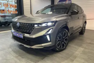 Renault Austral gris métallisé en 3/4 avant droit, avec calandre noire et jantes alliage 20 pouces distinctives.