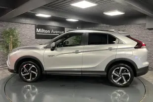 Profil côté gauche du Mitsubishi Eclipse Cross gris métallisé 2022 avec jantes alliage bi-ton et vitres surteintées.