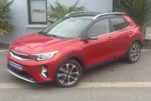 KIA Stonic rouge métallisé vue 3/4 avant droit avec jantes alliage et toit ouvrant panoramique.