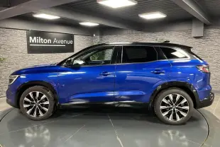 Profil côté gauche du Renault Austral 2023 bleu Iron avec toit noir étoilé et jantes alliage noires diamantées.