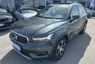 Volvo XC40 T4 190 CV gris foncé métal en 3/4 avant droit, avec calandre chromée et jantes alliage distinctives.