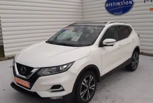 Nissan Qashqai blanc en 3/4 avant droit, toit noir, jantes alliage bicolores et calandre V-Motion distinctive.