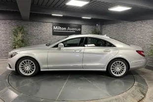 Profil droit d'une Mercedes Classe CLS 350 d gris métallisé avec jantes alliage multibranches en showroom.