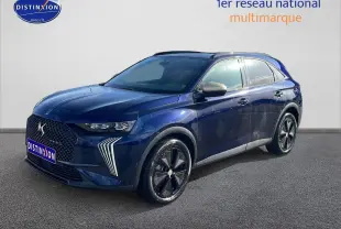 DS7 bleu 3/4 avant droit avec calandre distinctive et jantes noires brillantes sur fond neutre.
