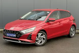 Vue 3/4 avant d'une Hyundai i20 2025 rouge Dragon Metal avec jantes alliage et calandre noire distinctive.