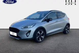 Vue 3/4 avant droit d'une Ford Fiesta 1.0 EcoBoost gris lunaire avec jantes alliage et barres de toit noires.