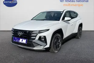 Hyundai Tucson blanc Atlas en 3/4 avant droit, avec calandre noire et jantes alliage noires distinctives.