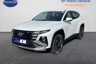 Hyundai Tucson blanc Atlas en 3/4 avant droit, avec calandre noire et jantes foncées distinctives.