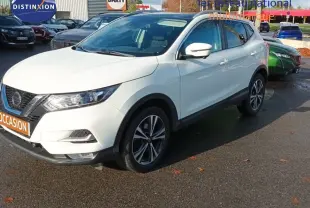 Nissan Qashqai blanc en 3/4 avant droit, avec jantes alliage bicolores et calandre distinctive noire.