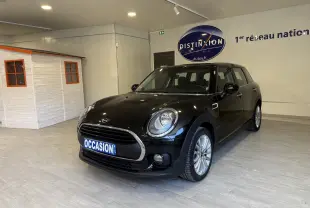 MINI Clubman noir vue 3/4 avant droit en intérieur avec plaque "OCCASION" visible sur la calandre.
