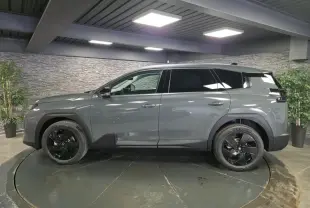 Vue de profil côté gauche d'un Citroën C5 Aircross 2026 vert métallisé avec jantes alliage noires en showroom.