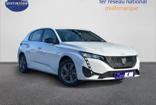 Vue 3/4 avant gauche d'une Peugeot 308 blanche avec calandre noire et feux LED verticaux distinctifs.