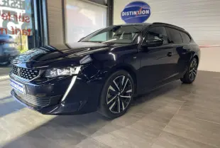 Peugeot 508 SW bleu foncé vue 3/4 avant droit en intérieur avec jantes alliage et calandre distinctive.