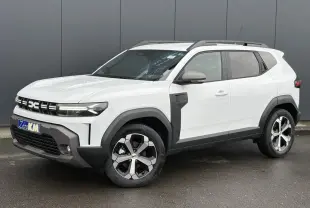 SUV Dacia Duster blanc glacier vu en 3/4 avant droit, avec jantes alliage et barres de toit noires.