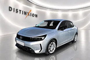 Opel Corsa gris alu vue 3/4 avant droit dans un showroom lumineux avec logo Distinxion en arrière-plan.