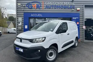 Vue 3/4 avant d’un Citroën Berlingo Fourgon blanc stationné devant un garage Gregory Marie Automobiles.