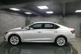 Profil côté gauche d'une Skoda Octavia gris métallisé 2023 dans un showroom avec jantes alliage 17 pouces.