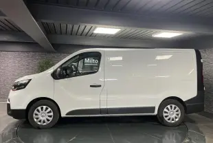 Profil côté gauche du fourgon blanc Nissan Primastar N-Connecta 2022 avec enjoliveurs de roues et protections noires.