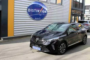 Renault Clio hybride noire étoile métal vue 3/4 avant droit, avec calandre distinctive et jantes bicolores.