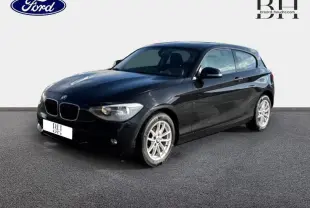 BMW Série 1 114i noire vue en 3/4 avant droit, avec jantes alu et lignes profilées visibles.
