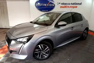 Peugeot 208 gris clair vue 3/4 avant droit, avec feux LED et jantes alliage dans un showroom intérieur.