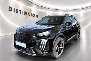Peugeot 2008 noir en 3/4 avant droit, avec calandre noire et feux LED distinctifs en intérieur showroom.
